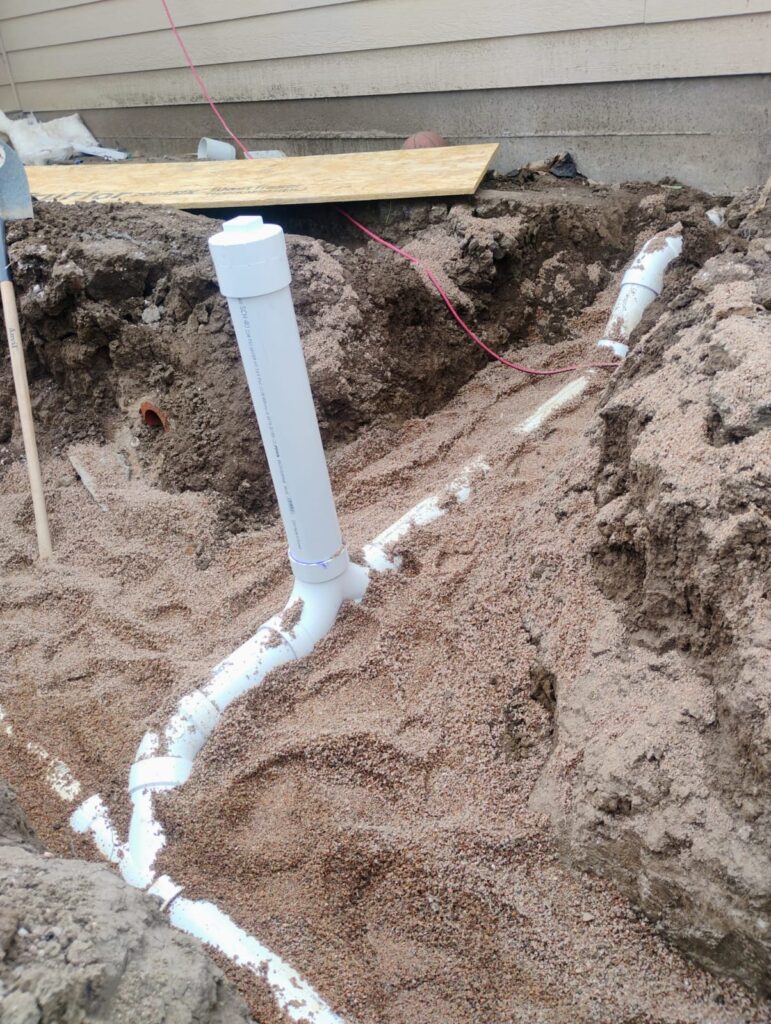 New white sewer pipe installed in a residential excavation